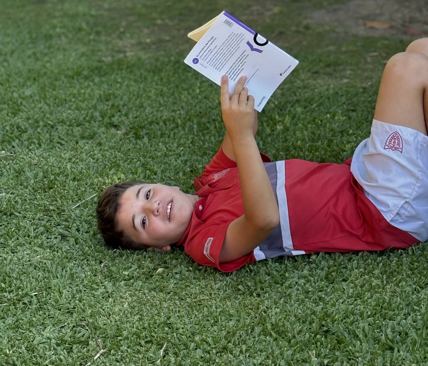 Alumno leyendo al aire libre en el campus